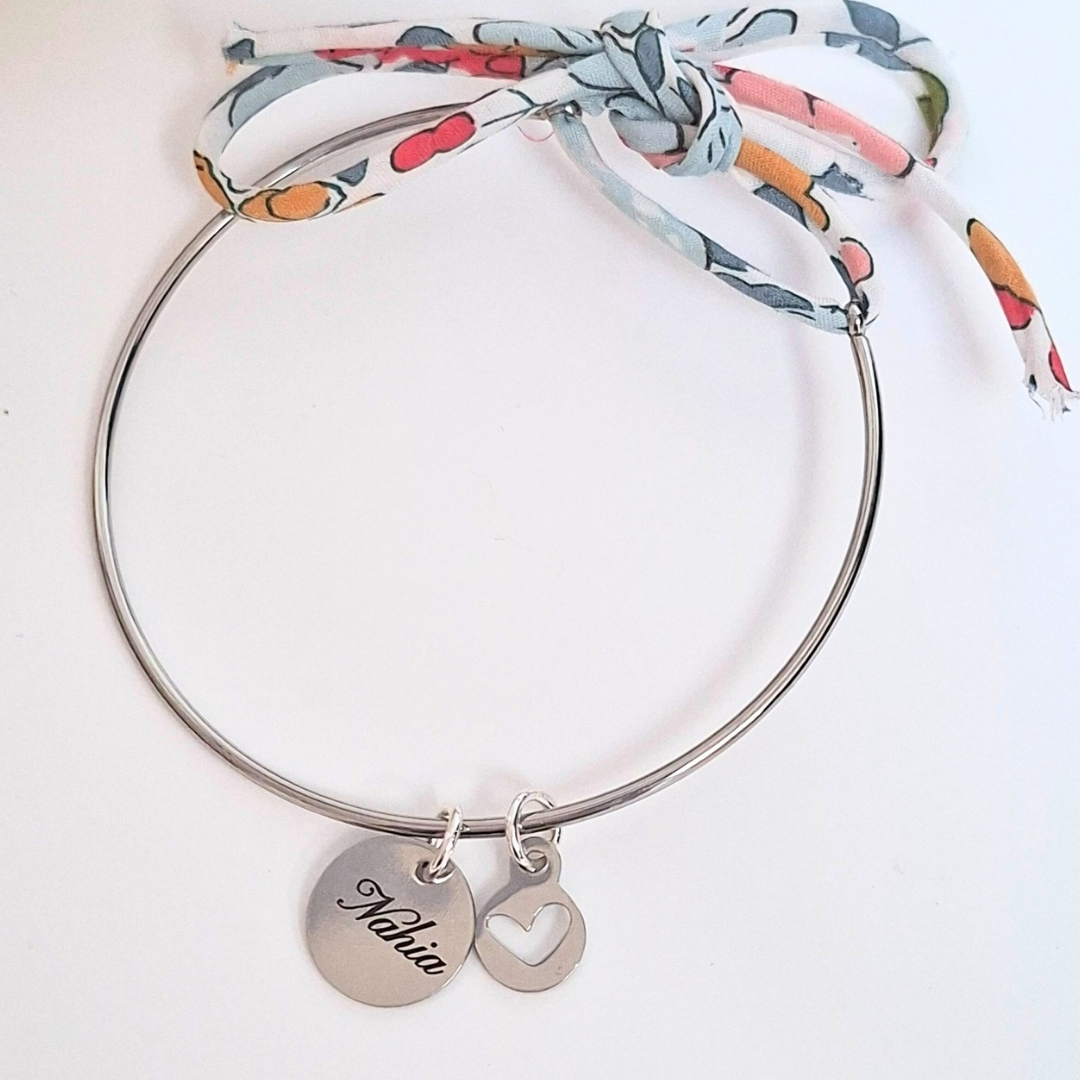 Bracelet jonc gravé porté au poignet avec médailles prénom et cœur – acier inoxydable argenté
