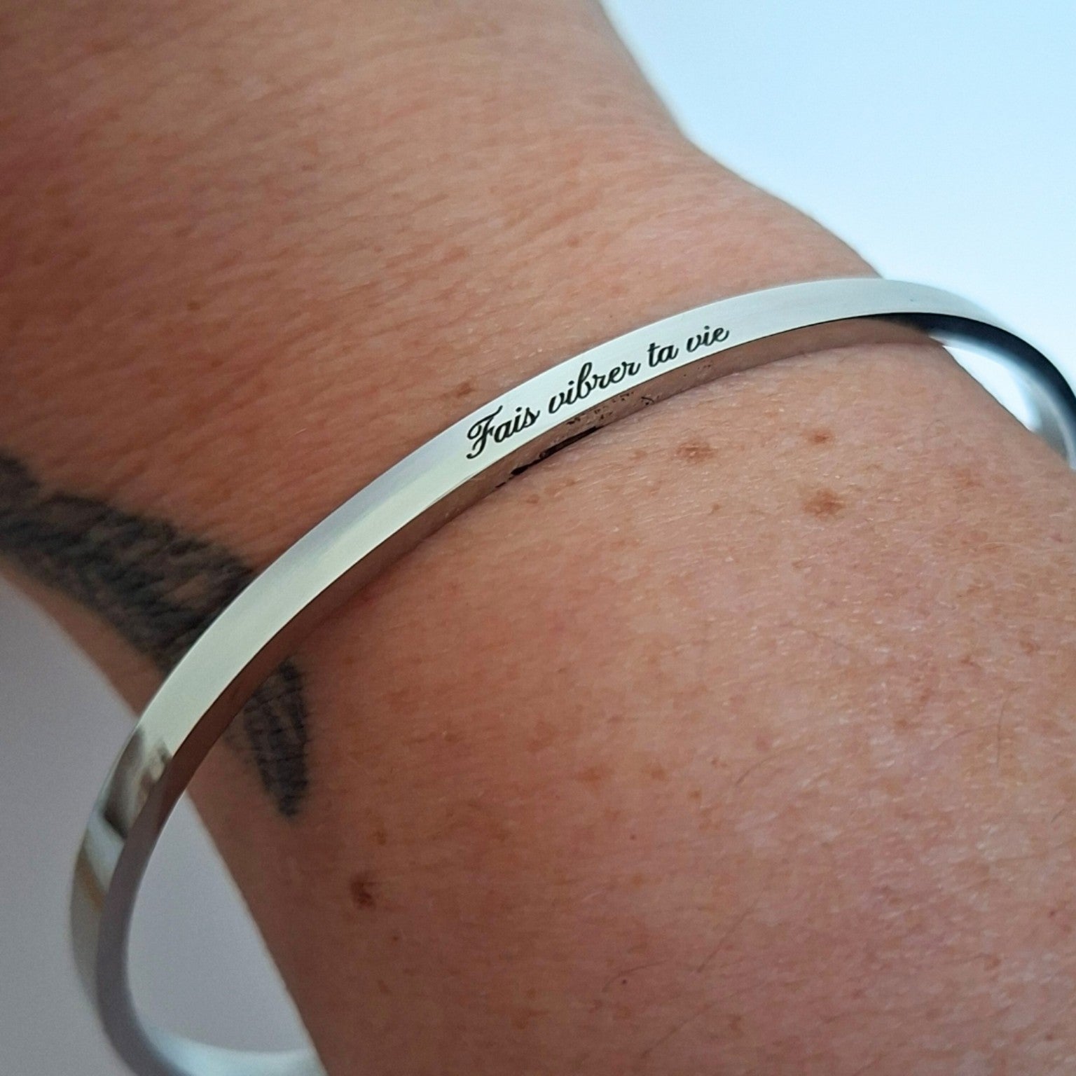 Bracelet argenté gravé Fais vibrer ta vie porté au poignet
