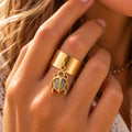 Bague scarabée en aventurine naturelle dorée ajustable portée sur une main