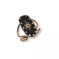 Bague dorée avec pierre noire portée au doigt femme