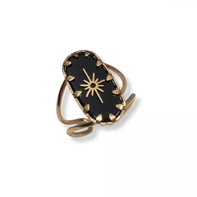 Bague dorée avec pierre noire portée au doigt femme