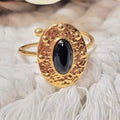 Bague dorée martelée avec pierre noire ovale vue de côté