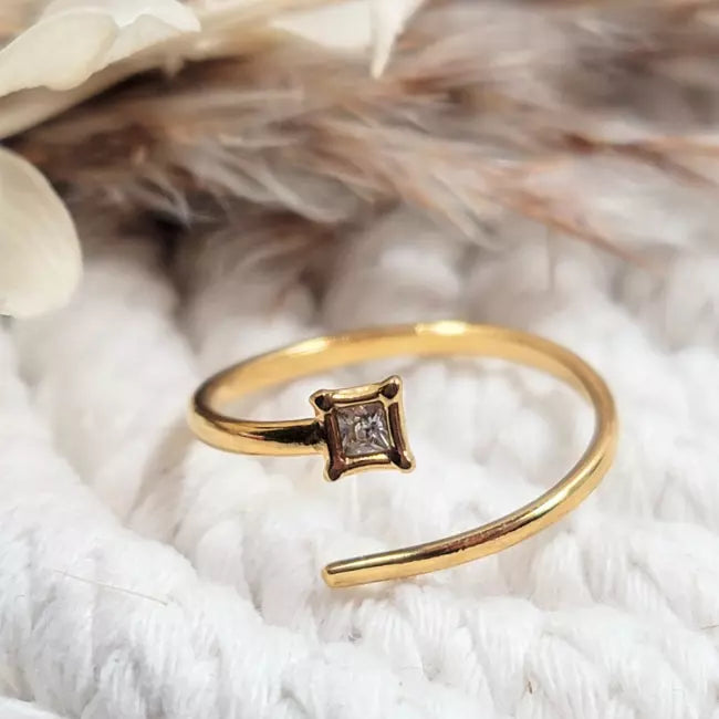 Bague ajustable dorée en acier inoxydable avec zircon carré, portée au doigt d’une femme