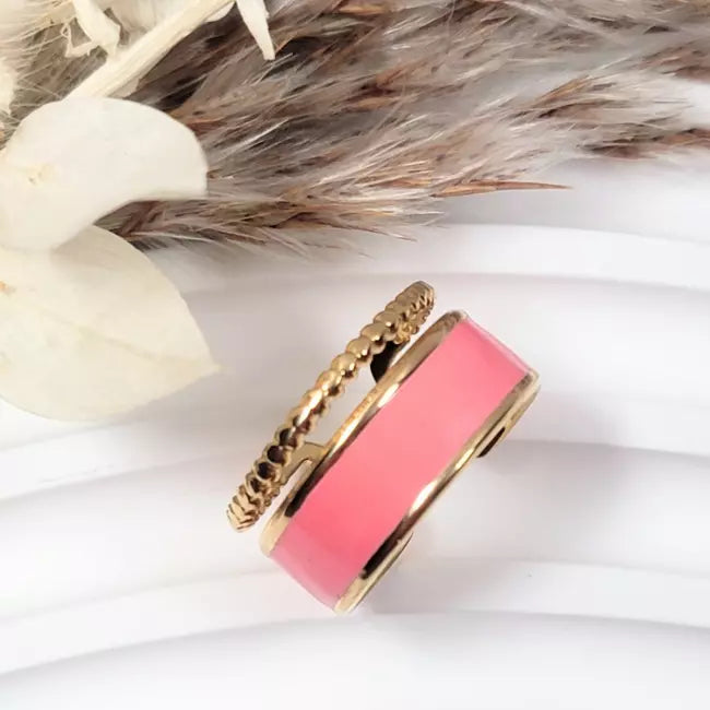 Bague dorée femme ajustable en acier inoxydable avec émail rose — vue portée au doigt.