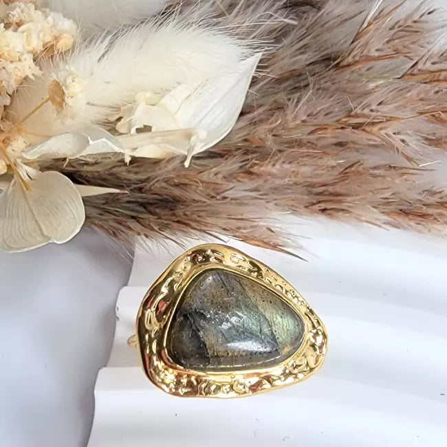 Bague dorée femme martelée en acier inoxydable ajustable, cabochon labradorite grise — portée au doigt.