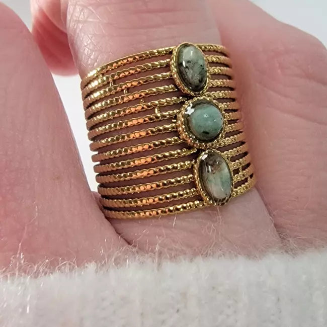Bague dorée large multi-rangs portée, acier inoxydable ajustable, 3 cabochons noirs — gros plan.
