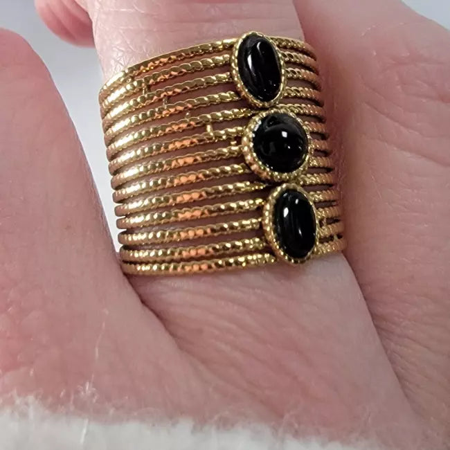 Bague dorée large multi-rangs portée, acier inoxydable ajustable, 3 cabochons noirs — gros plan.