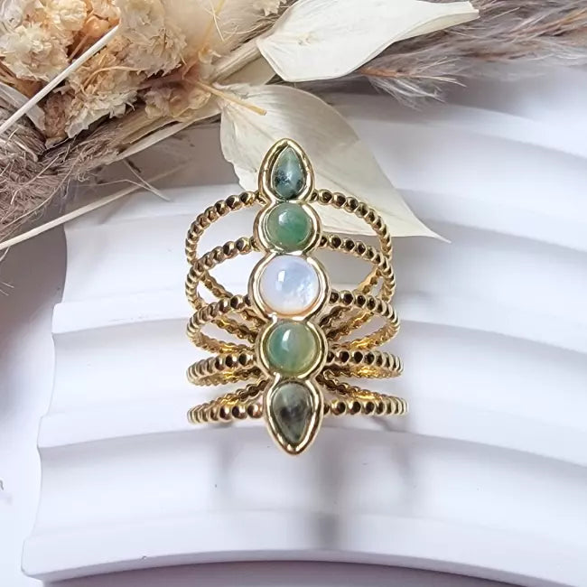 Bague dorée femme multi-rangs en acier inoxydable ajustable, décorée de cabochons verts et blanc nacré — vue portée au doigt.