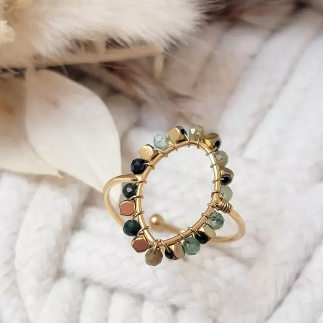 Bague dorée ajustable en acier inoxydable, forme amande décorée de perles, portée au doigt d’une femme