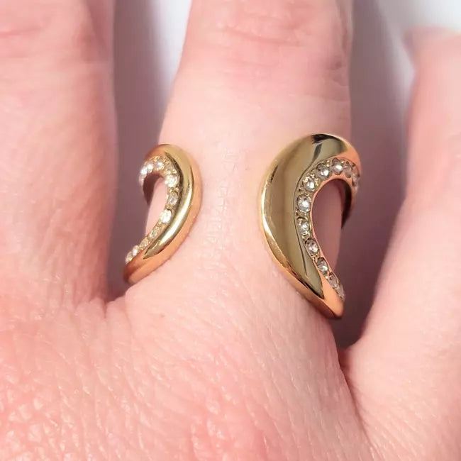 Bague ouverte argentée portée au doigt avec strass brillants