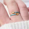 Bague serpent turquoise et dorée en acier inoxydable, portée au doigt d’une femme