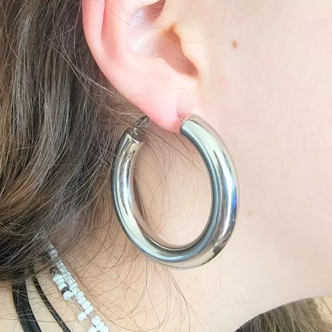 Boucles d’oreilles créoles épaisses argentées portées – acier inoxydable brillant