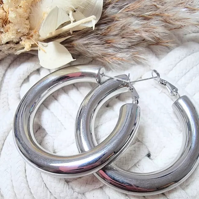 Boucles d’oreilles créoles épaisses argentées portées – acier inoxydable brillant