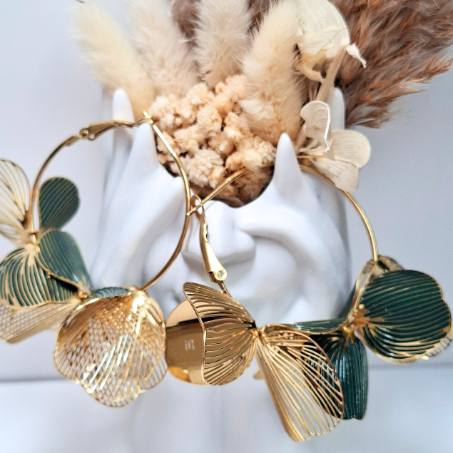 Boucles d’oreilles créoles dorées avec fleurs ajourées vert et or portées à l’oreille