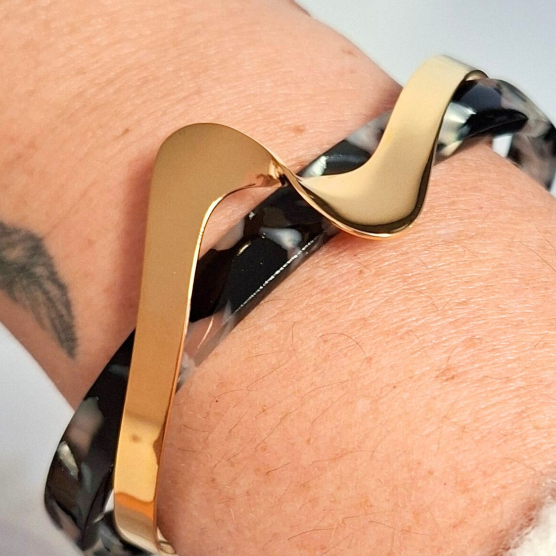 Bracelet manchette ondulé doré avec bandeau en acétate marbré posé en décor bohème