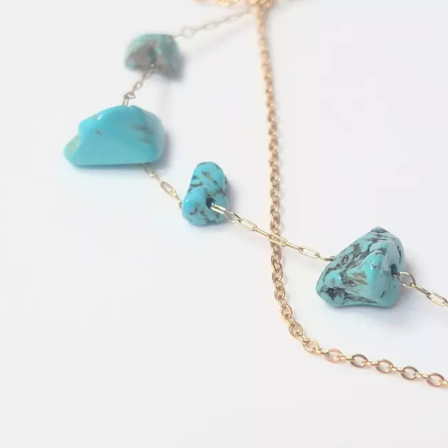 Détails pierres turquoise naturelles sur bracelet de cheville doré