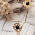 Bracelet doré élégant avec cabochons noirs et détails ajourés