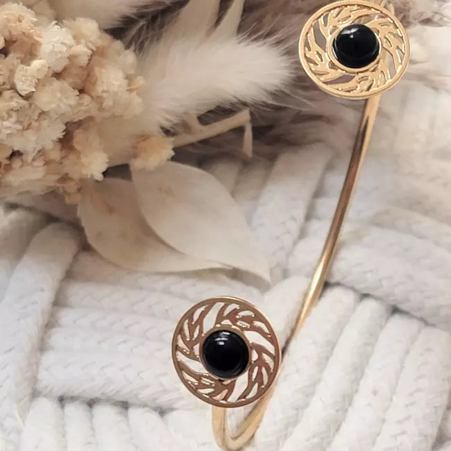 Bracelet doré élégant avec cabochons noirs et détails ajourés