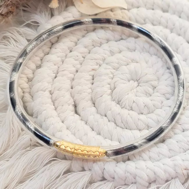 Bracelet jonc femme argenté en acier inoxydable avec détail doré porté au poignet