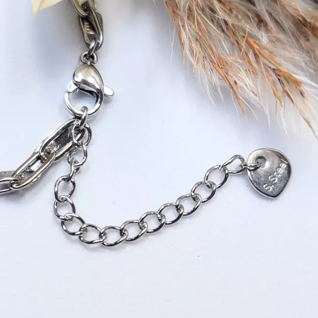 Détail fermoir chaîne de cheville en acier inoxydable avec pendentif cœur argenté