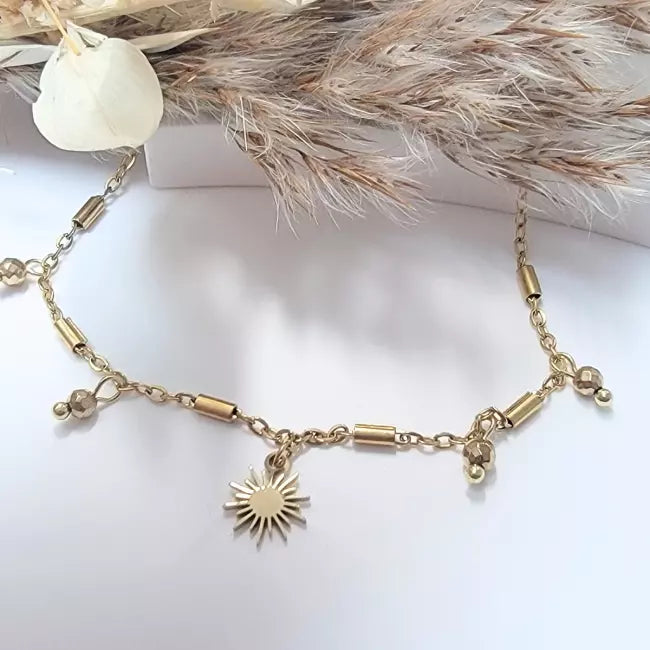 Chaîne de cheville femme dorée avec pendentif soleil, bijou tendance été