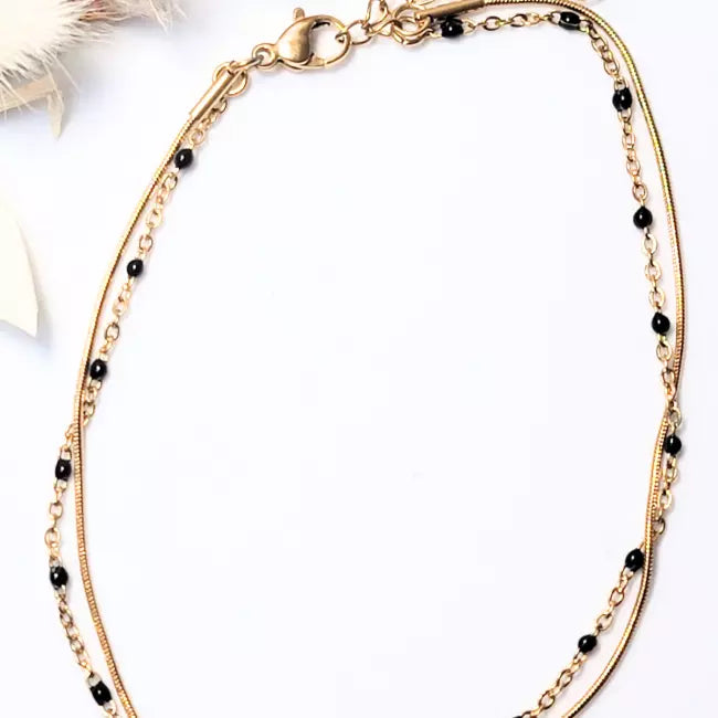 Chaîne de cheville femme dorée en acier inoxydable avec perles noires