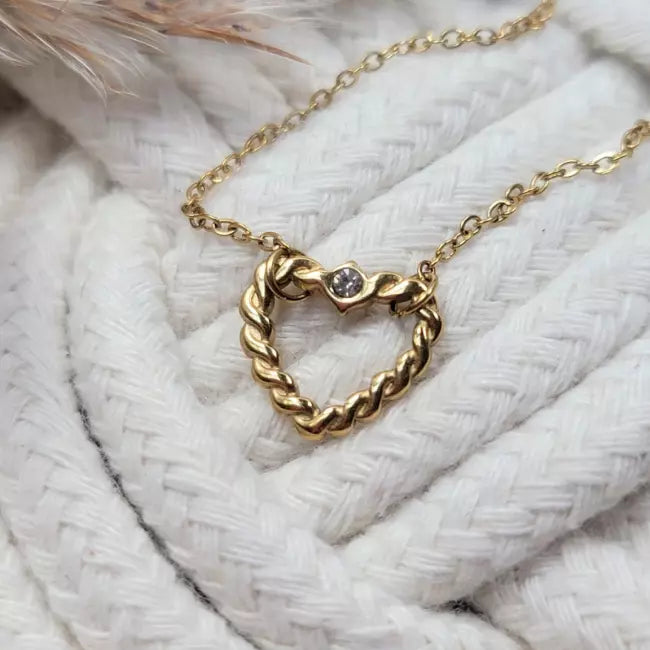 Collier cœur torsadé argenté porté, pendentif ajouré avec petit strass sur fine chaîne.