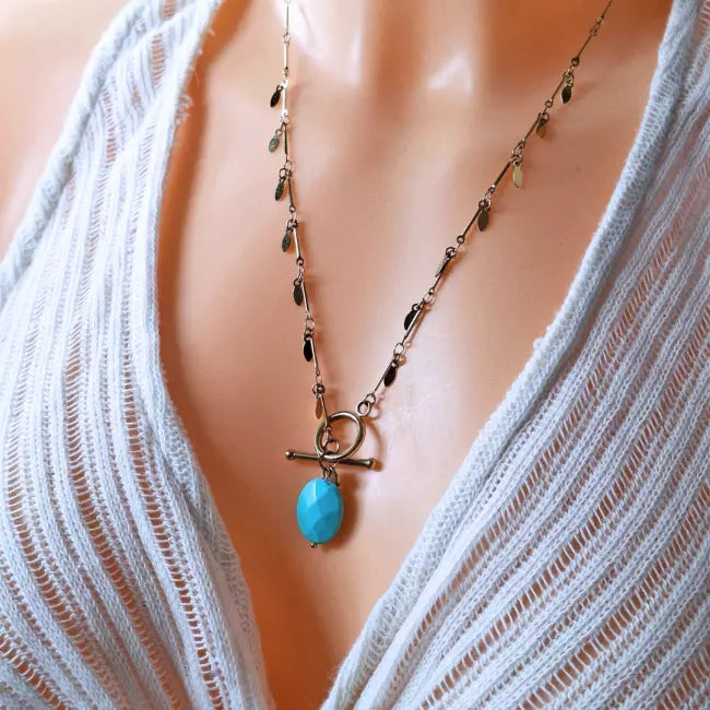 Collier doré en acier inoxydable porté, pendentif vert marbré ovale et chaîne à pampilles, fermoir toggle chic.