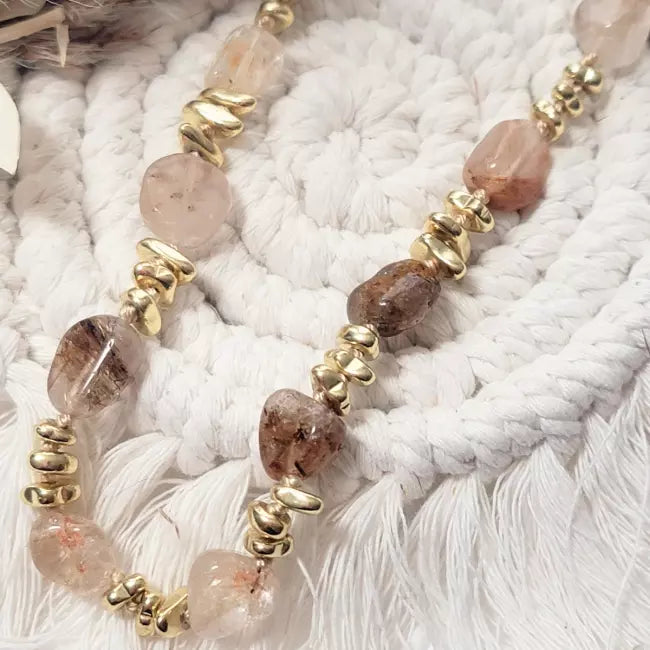 Collier doré femme avec pierres naturelles, porté, style bohème chic.