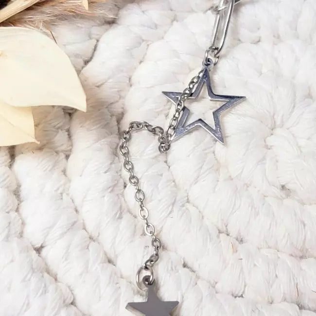 Collier étoile doré porté, chaîne à gros maillons avec pendentifs étoiles en cascade, style tendance.
