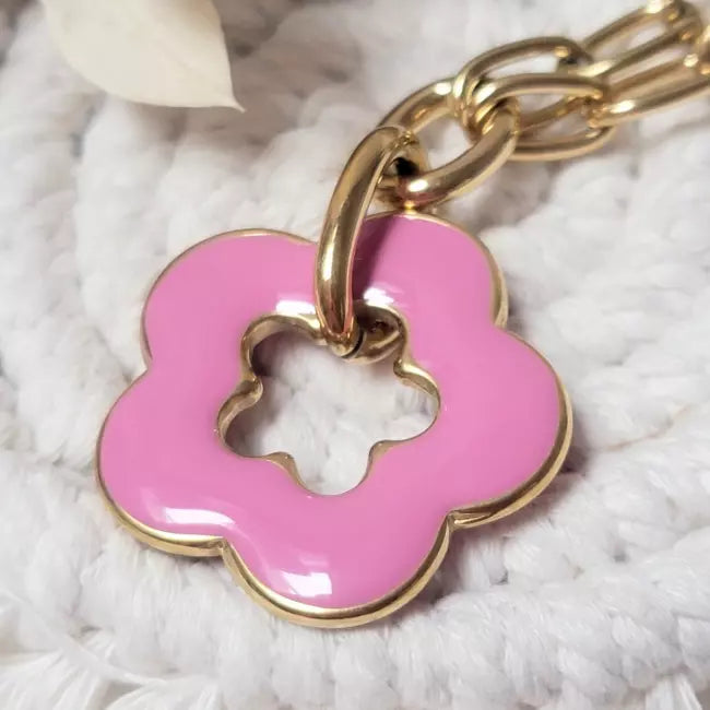 Collier fleur rose en acrylique porté, pendentif en forme de fleur sur chaîne dorée à gros maillons.