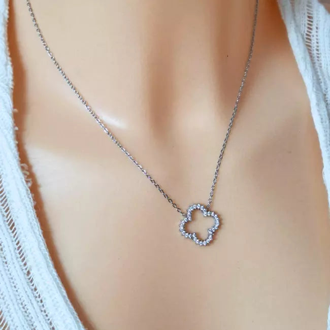 Collier fleur argenté en acier inoxydable porté, pendentif en strass brillant en forme de fleur ajourée.
