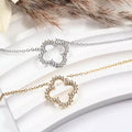 Colliers fleur en strass, acier inoxydable argenté et doré, pendentifs brillants en forme de fleur ajourée.