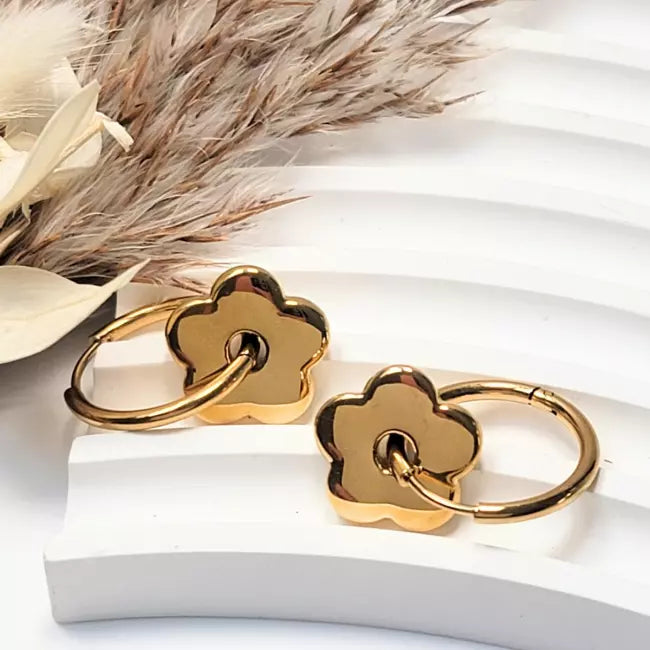 Boucles d’oreilles créoles fleurs argentées en acier inoxydable portées par une femme
