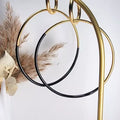 Boucles d’oreilles créoles dorées et noires en acier inoxydable – vue en suspension