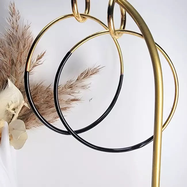 Boucles d’oreilles créoles dorées et noires en acier inoxydable – vue en suspension