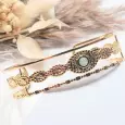 Bracelet manchette en acier inoxydable doré, cabochon vert, vue latérale montrant les trois bandes et la finition brillante.