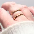 Main portant une bague double dorée en acier inoxydable à effet miroir