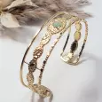 Bracelet jonc manchette doré en acier inoxydable avec cabochon vert, vue 3/4 posée, style boheme chic, bijou femme ajustable.