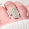 Bague argentée à spirale portée au doigt, bijou moderne pour femme sur main claire