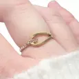 Bague dorée portée au doigt, avec design elliptique et strass, en lumière naturelle
