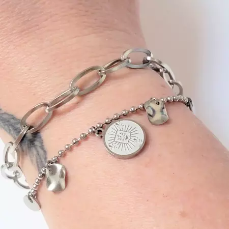 Bracelet acier inoxydable porté au poignet, double chaîne avec médaillon et pampilles