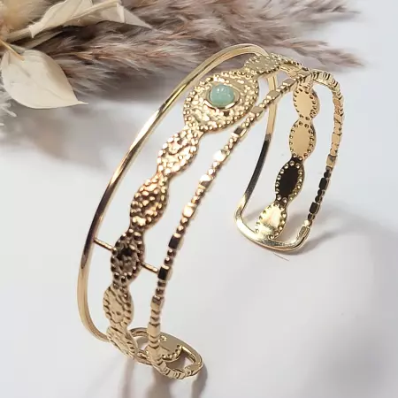 Bracelet jonc manchette doré en acier inoxydable avec cabochon vert, vue 3/4 posée, style boheme chic, bijou femme ajustable.