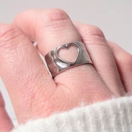 Bague cœur argentée portée sur main, vue de face