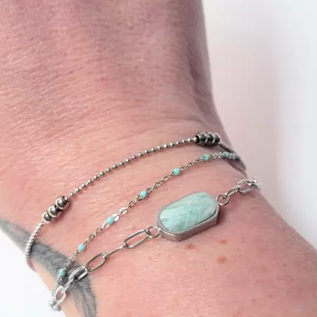 Bracelet amazonite porté au poignet avec détails des chaînes fines en acier inox