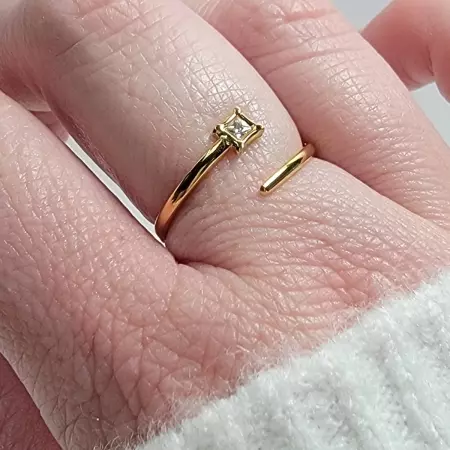 Bague dorée ajustable portée sur doigt, bijou féminin élégant et discret