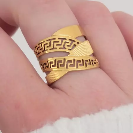 Bague dorée portée au doigt, bijou tendance au motif grec