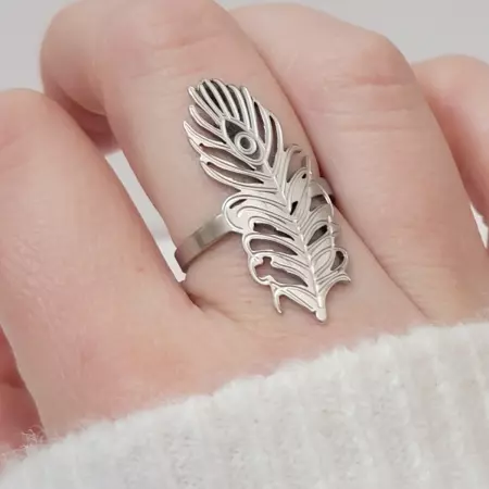 Bague plume argentée portée sur une main féminine