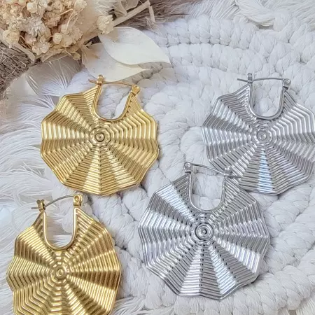 Boucles d’oreilles géométriques en acier inoxydable doré et argenté sur fond de macramé et fleurs séchées