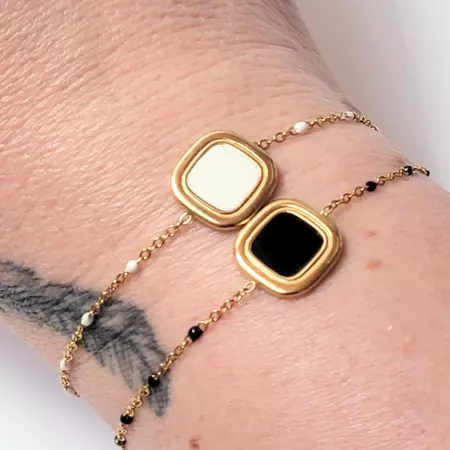 bracelets dorés portés au poignet, version noire et blanche côte à côte